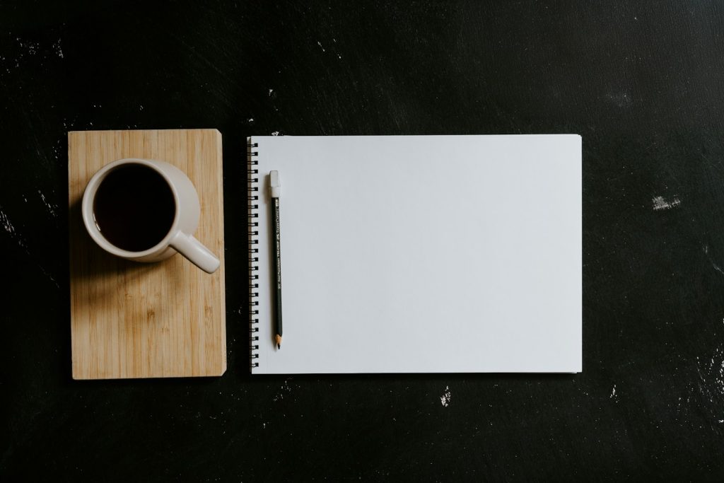 Cup of coffee and a notebook with a pencil