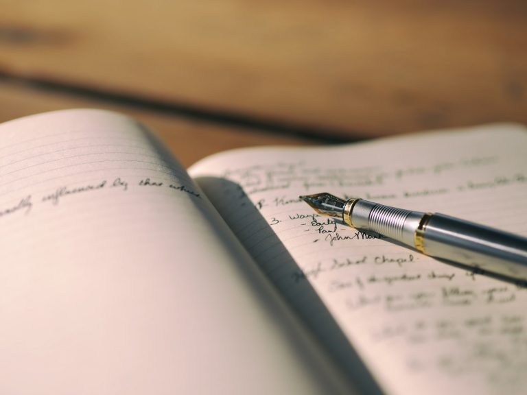 Fountain pen resting on a lined journal