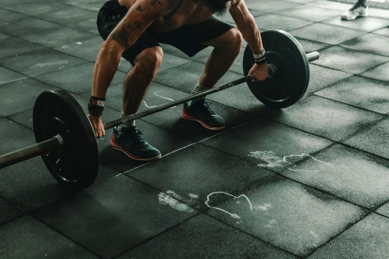 Person lifting a heavy barbell in a gym