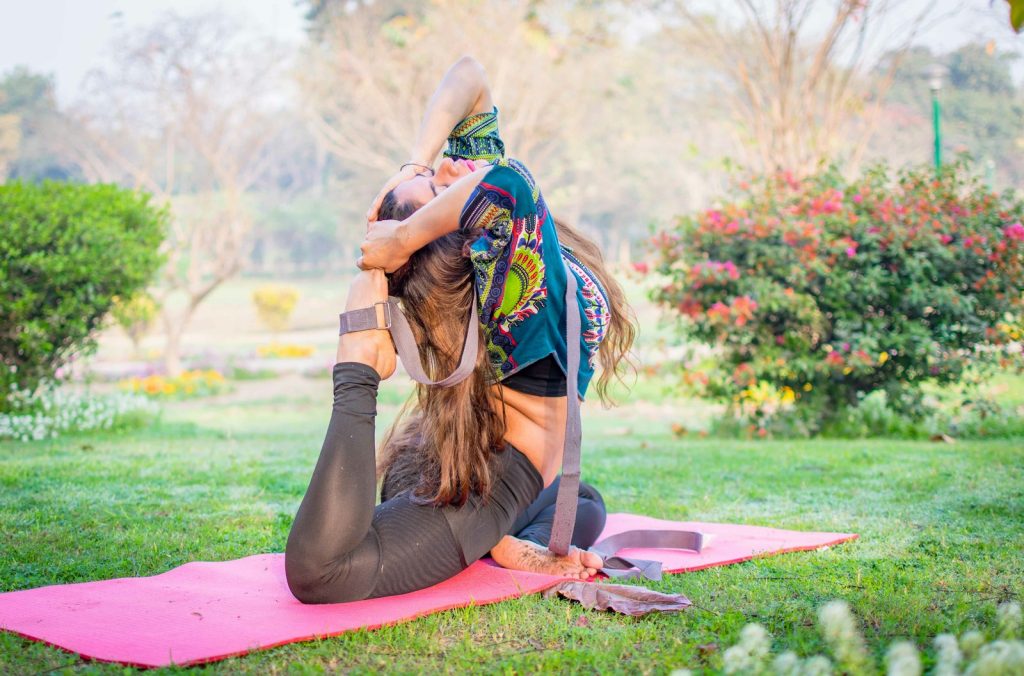 Woman sitting on a yoga mat in a park