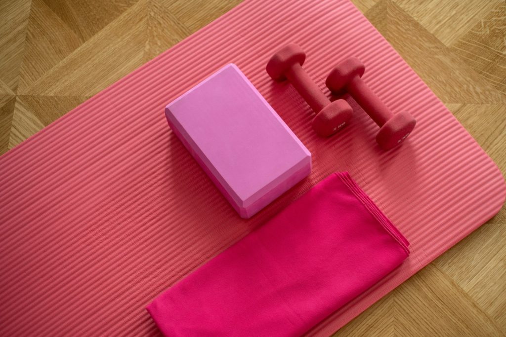Pink dumbbell resting on pink workout textile