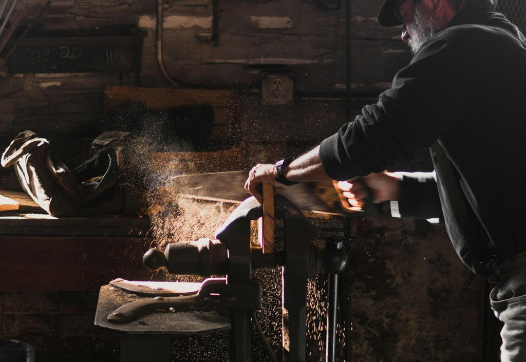 Man sawing wood in a workshop