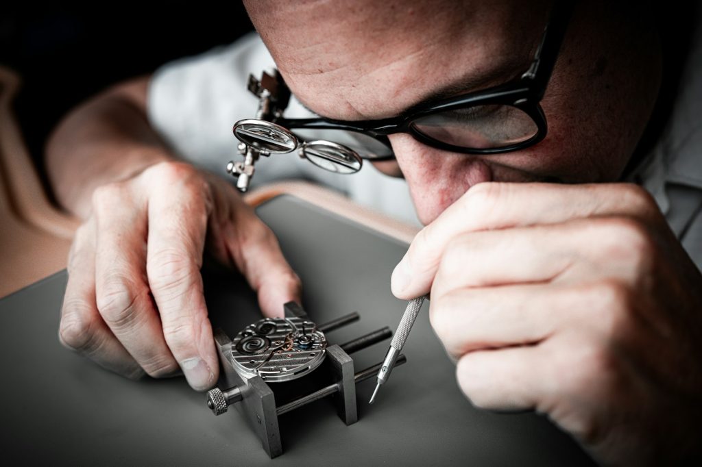 Watchmaker repairing a mechanical watch movement