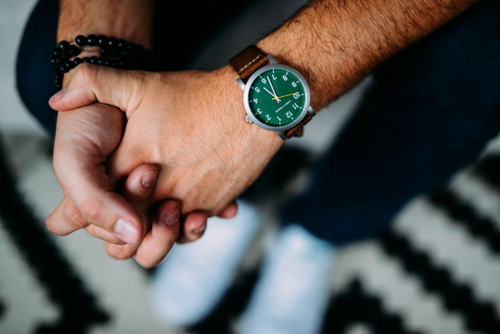 Man wearing a wristwatch with green face
