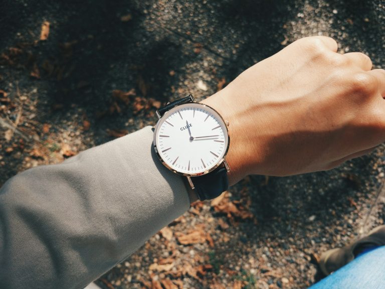 Wrist wearing a round silver analog watch