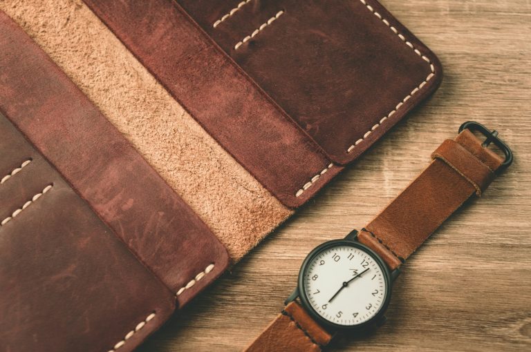 Watch beside a wallet on a table