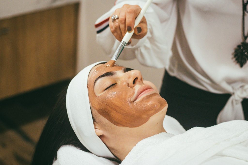 Woman receiving a facial mask treatment at a spa