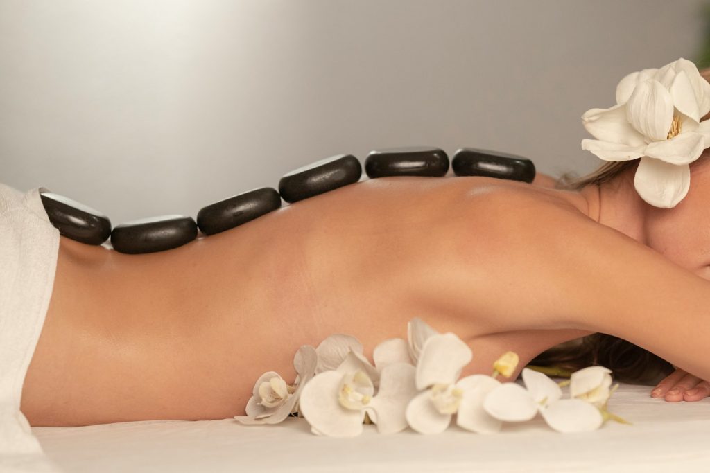 Woman receiving a hot stone massage at spa