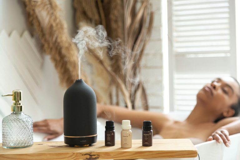 Woman relaxing in a bath beside essential oil