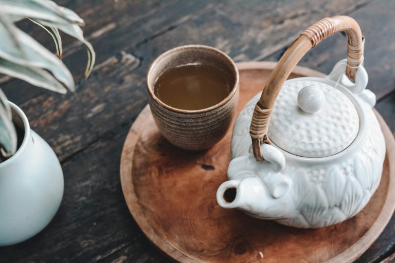 Ceramic teapot on a wooden tray