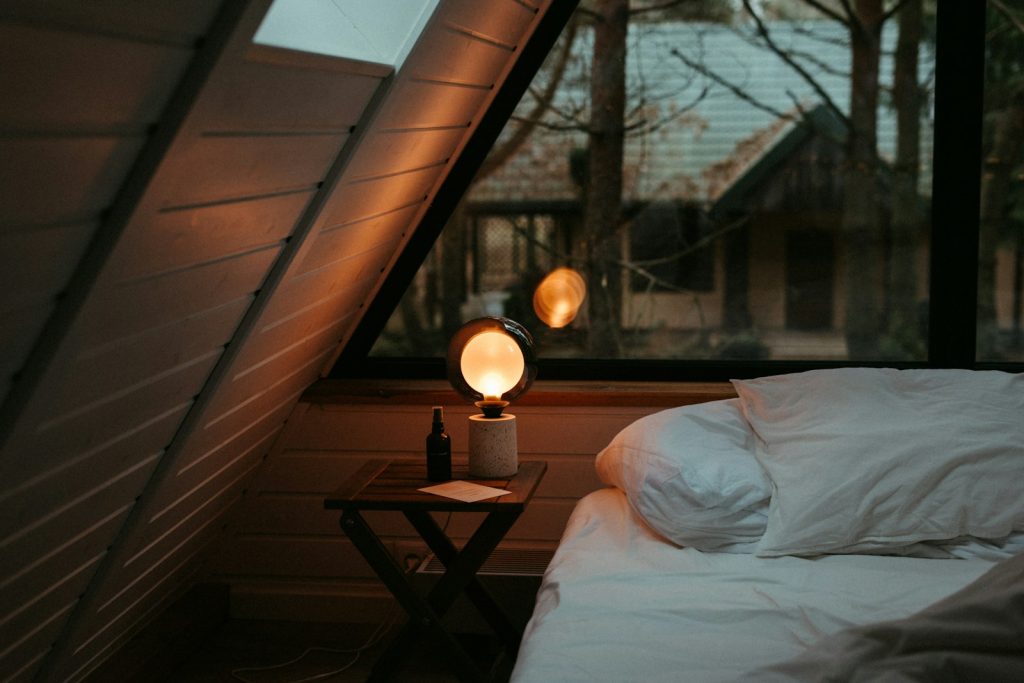 Calm bed beneath a window beside a nightstand