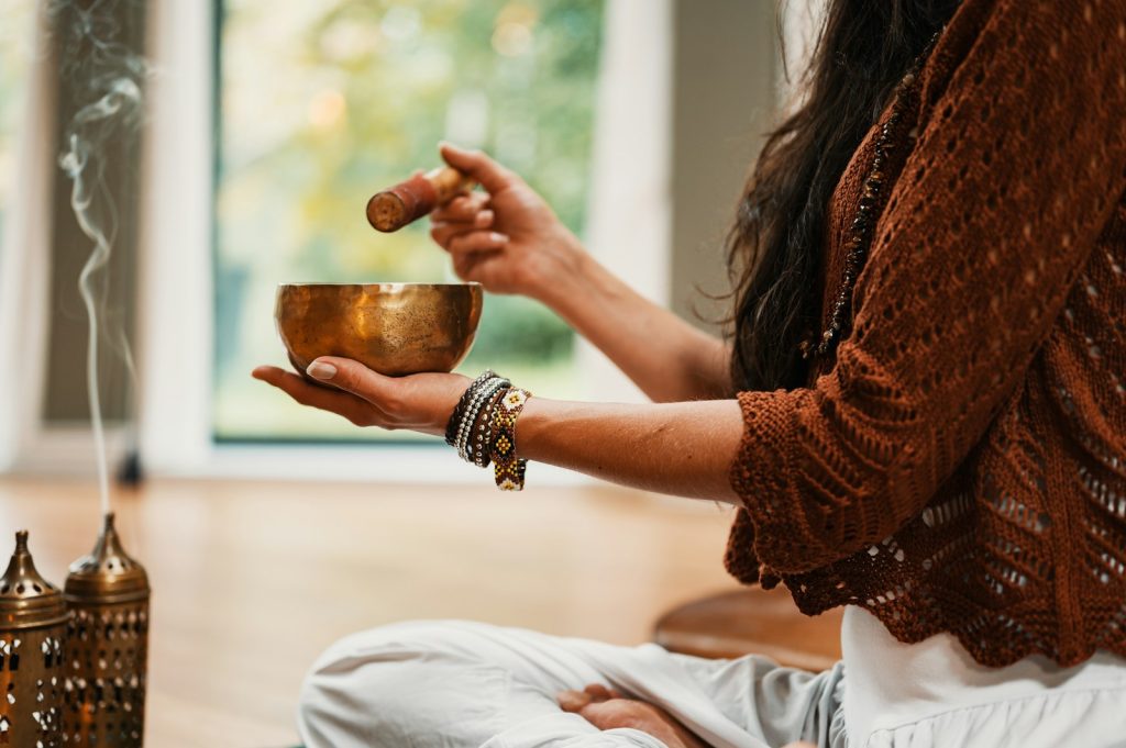 Person holding singing bowl with incense smoke